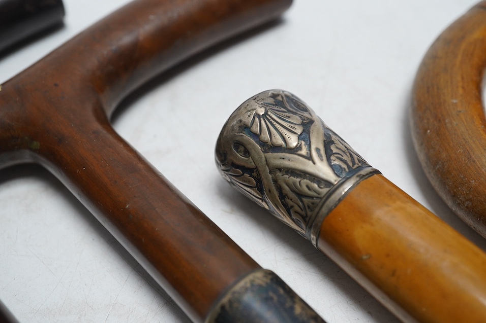 Four mixed silver mounted walking sticks, a riding crop and a baton, longest 88cm. (6). Condition - fair considering use and age